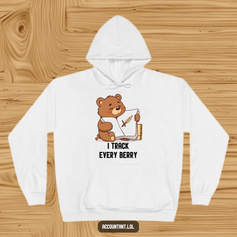 Funny determined brown bear scribbling furiously on a large ledger with a quill, featured on a warm hoodie.
